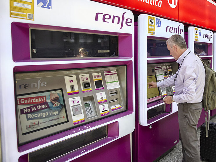 Una persona en una de las máquinas de venta de billetes.